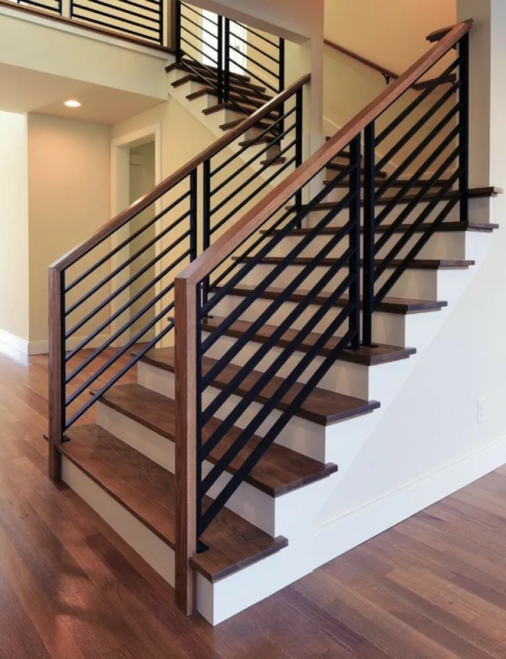 Railing tangga besi bergaris lurus tanpa ornamen di dalam rumah